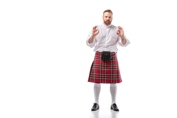 hombre barbudo pelirrojo escocés en horno tartán rojo que muestra gestos ok sobre fondo blanco - falda escocesa fotografías e imágenes de stock