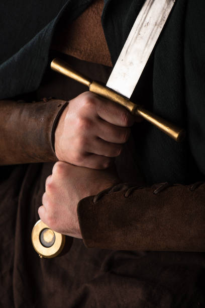 cropped view of medieval Scottish warrior with sword in hands