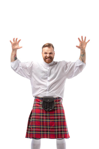 istock Scottish redhead man in red kilt scaring isolated on white 1235640371
