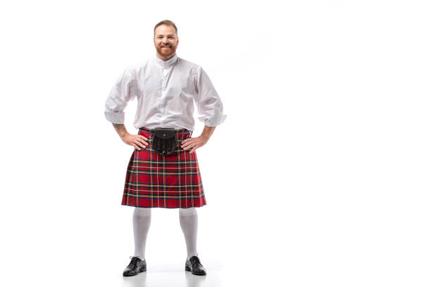 smiling Scottish redhead man in red kilt with hands on hips on white background smiling Scottish redhead man in red kilt with hands on hips on white background kilt stock pictures, royalty-free photos & images