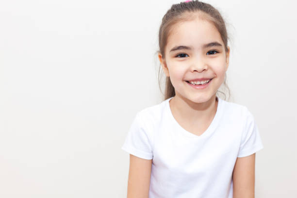 Portrait of a little girl with a cute smile in front of white background.