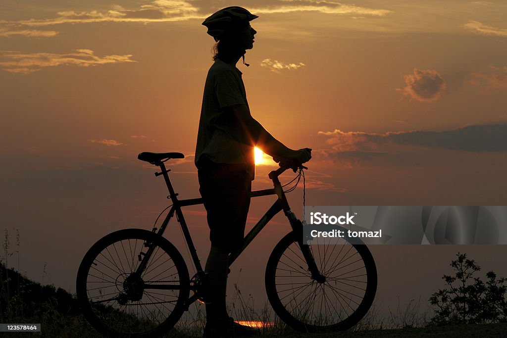Motociclista en puesta de sol - Foto de stock de Accesorio de cabeza libre de derechos