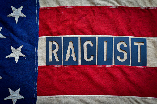 The word Racist spelled over the American Flag