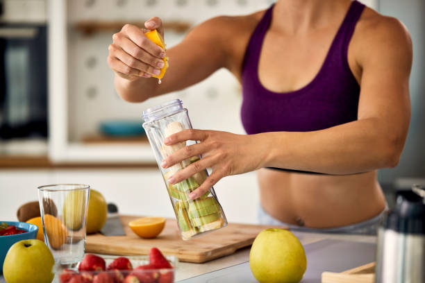 istock Unrecognizable athletic woman preparing healthy smoothie in the kitchen. 1235851176