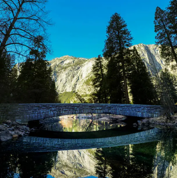 Stone bridge reflecting on the calm water in Yosemite National Park