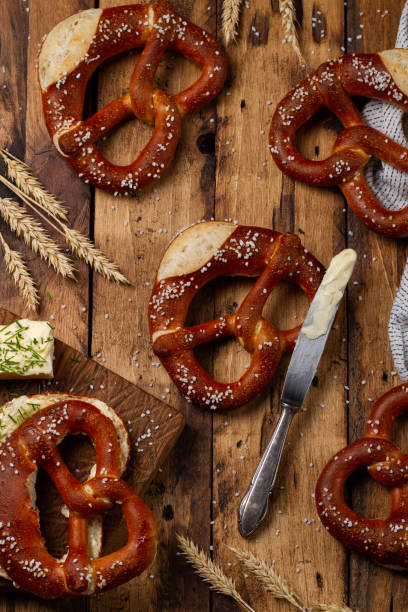 pretzel brezel alemán con mantequilla sobre fondo de madera. butterbrezel - pretzel german culture food salt fotografías e imágenes de stock