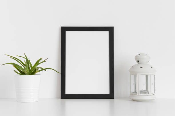 istock Black frame mockup with a succulent plant and a candle holder on a white table. Portrait orientation. 1235875652