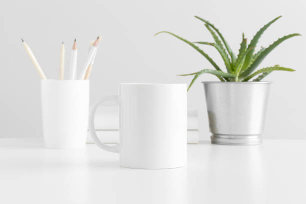 istock Mug mockup with workspace accessories and a succulent plant on a white table. 1235880826