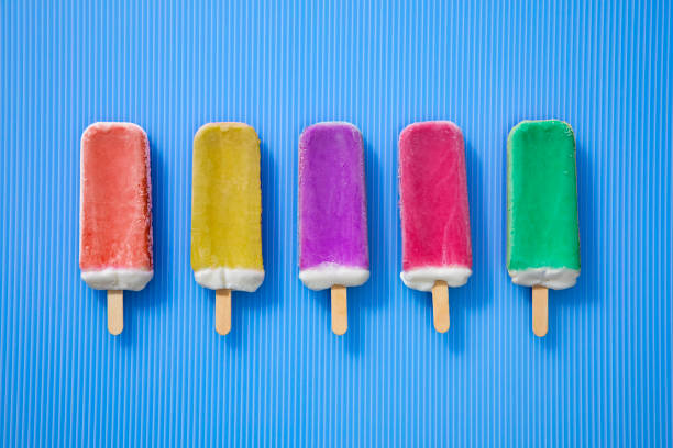 istock Rainbow Ice cream Popsicles in a Row on a blue background 1235893896