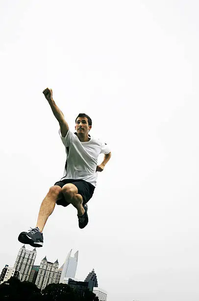 Goal! Young man jumping in mid air in superman pose