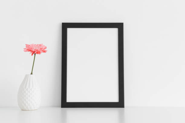 istock Black frame mockup with a chrysanthemum in a vase on a white table. Portrait orientation. 1235901773