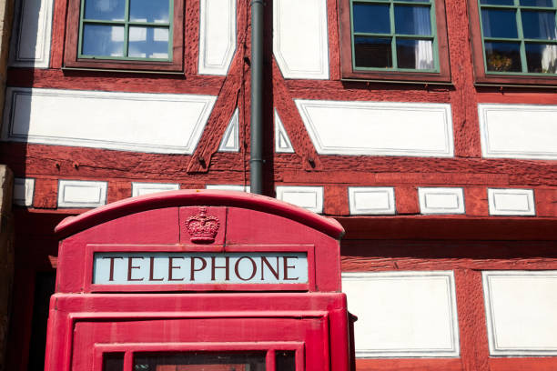 istock Public British telephone booth in front of a half-timbered house 1235942937