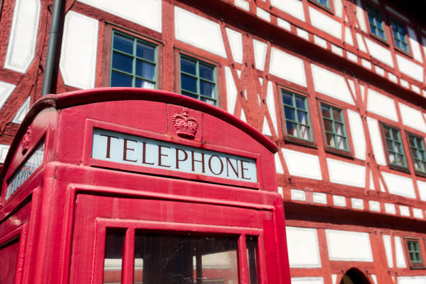 istock Public British telephone booth in front of a half-timbered house 1235943991