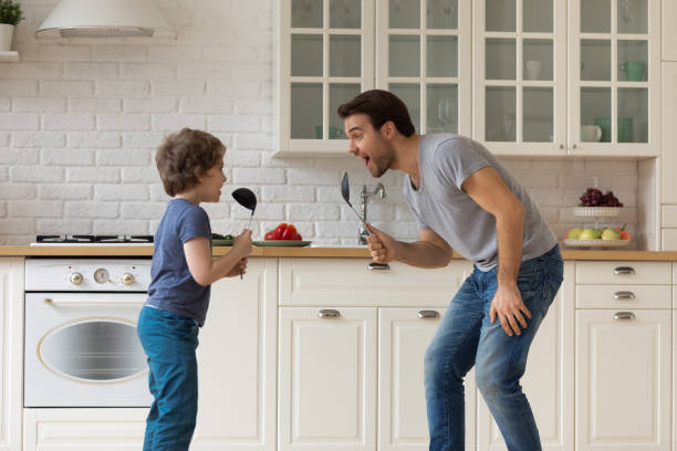 istock Overjoyed young father sing in home kitchen with son 1235945055
