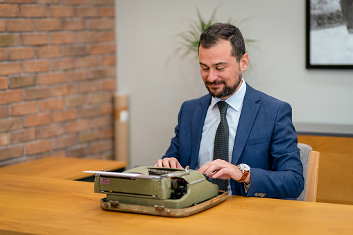 A businessman writing with a typewriter