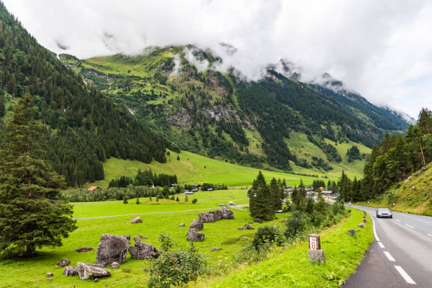istock Green mountains covered with forest and grass under big white clouds 1235968996