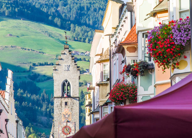 fiori colorati in vipiteno, splendida città delle alpi italiane, con la bellissima porta medievale del centro storico - eagle tower foto e immagini stock