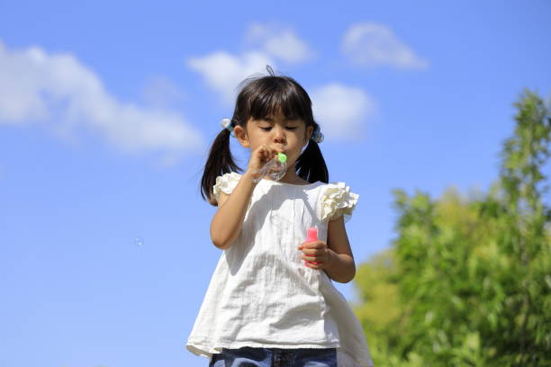 istock Japanese girl playing with bubble under the blue sky (5 years old) 1236027308