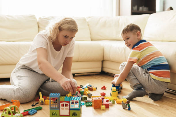 istock Cute boy and his mother playing together at home 1236049472