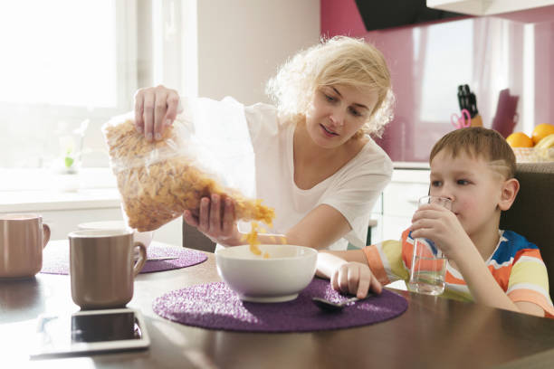 istock Beautiful mother and her cute son eating cornflakes for breakfast 1236051700