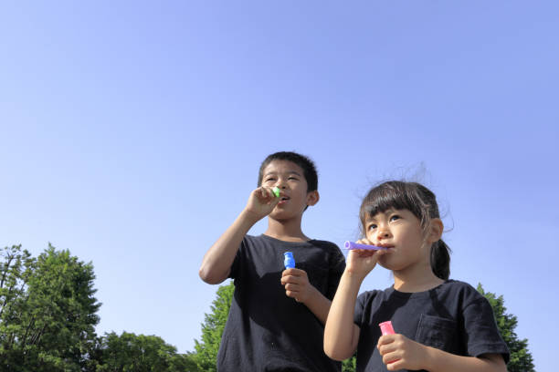 istock Japanese brother and sister playing with bubble under the blue sky (10 years old boy and 5 years old girl) 1236060251