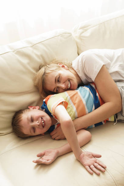 istock Laughing mother and son relaxing on the sofa 1236060804