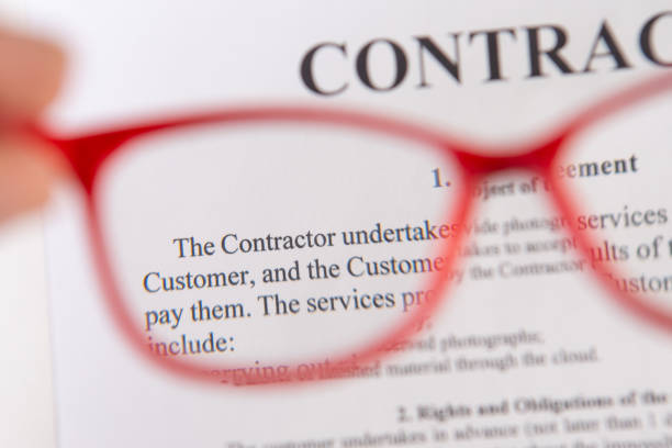 istock Close up of contract with red reading glasses in hand 1236073878