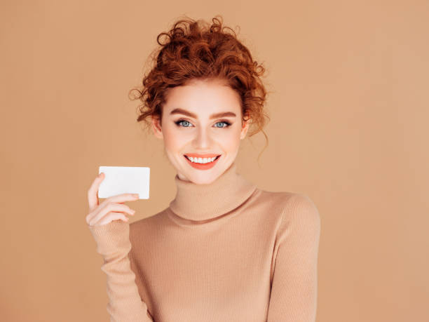 hermosa mujer sostiene pancarta - smiling business card horizontal women fotografías e imágenes de stock