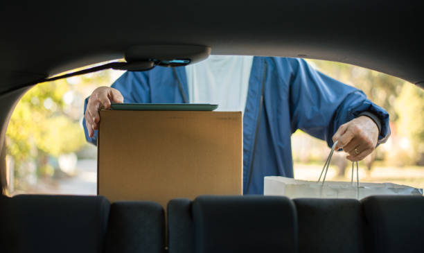 istock Delivery man taking parcels from his car 1236084967