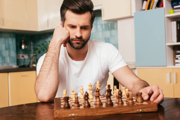 istock Selective focus of thoughtful man sitting near chess on chessboard on table 1236105633