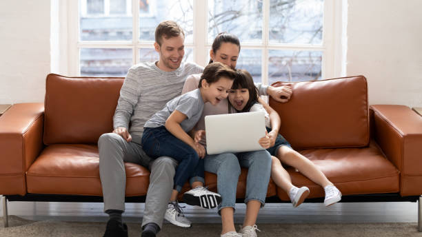 istock Happy young family with kids have fun using laptop 1236116990