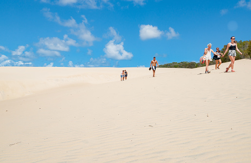Fraser Island Australia - March 13 2014; Tourists walking through sand of Lake Wabby sand blow