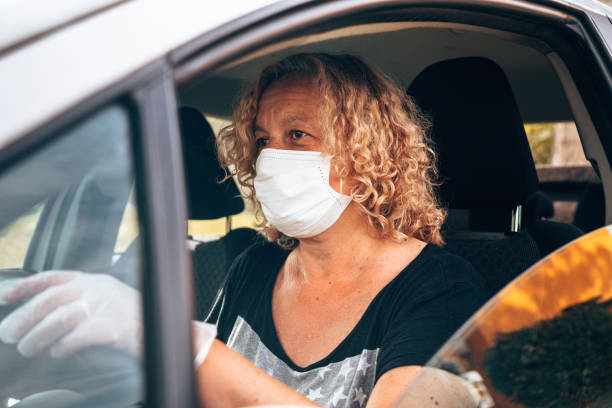 istock woman driving with car with face mask 1236170773