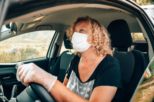 istock woman driving with car with face mask 1236171800