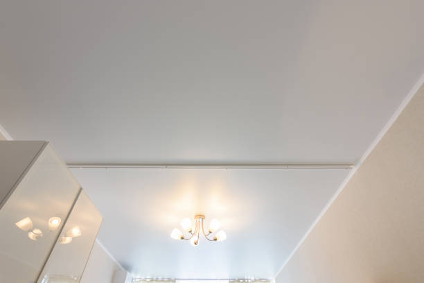 istock Classic white matte stretch ceiling with five lamp chandelier in the center 1236223200