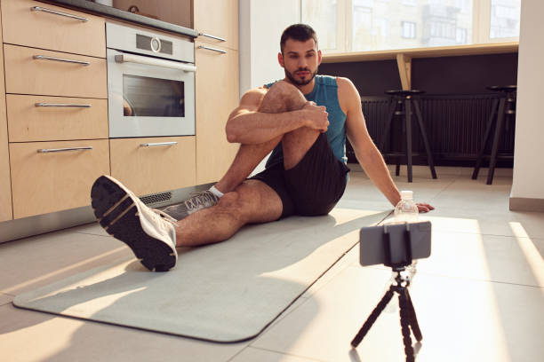 istock Handsome young man working out online at home 1236231955