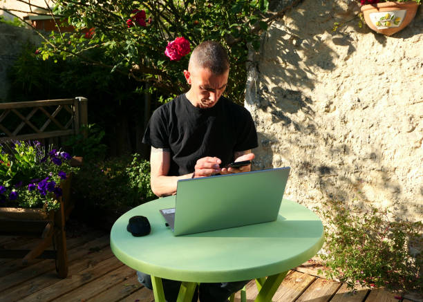 istock Man working on a laptop at home in his garden. 1236253039