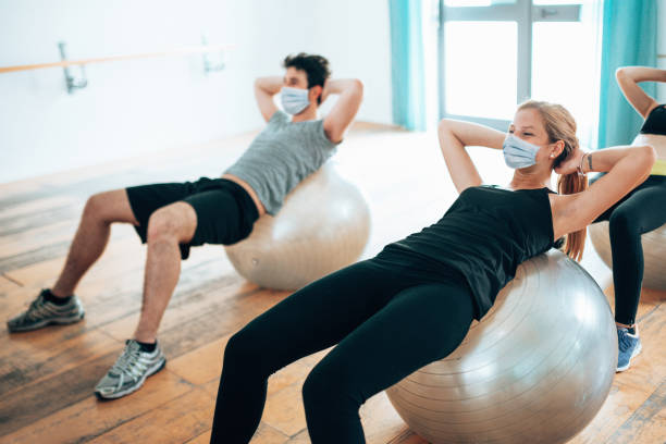 donna in palestra durante il covid19 facendo addominali - treadmill exercise machine isolated exercising foto e immagini stock