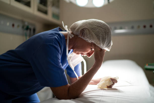 обеспокоенный здравоохранения старший врач-женщина в операционной в больнице - doctor tired protective workwear sadness стоковые фото и изображения