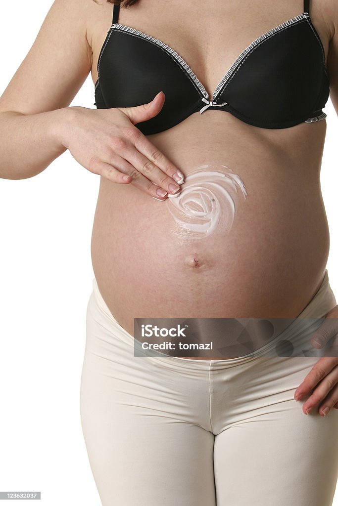 Appliquer hydratant le ventre de femme enceinte - Photo de Abdomen libre de droits