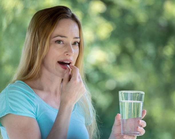 istock Woman opens her mouth to take vitamin 1236331341