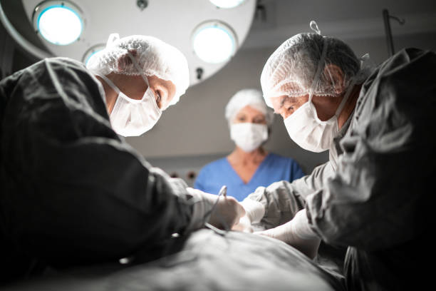 doctors doing a surgery on operating room in hospital - liposuction imagens e fotografias de stock