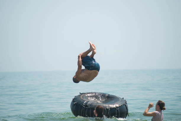 istock Man jumps from an inflated camera into the sea 1236345779