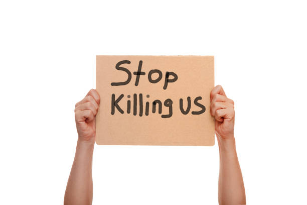 istock protest poster with the message Stop Killing Us, holding demonstration cardboard with text in hands isolated on a white background, a cononept for theme events in Minneapolis. 1236357009