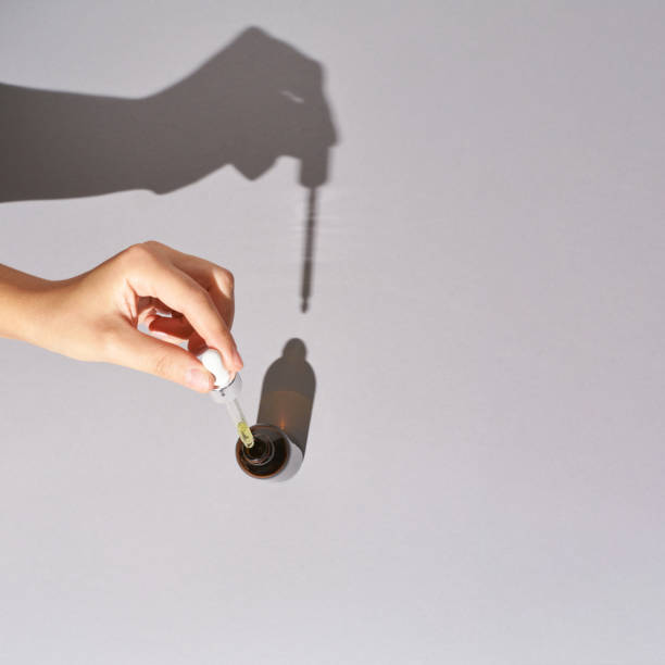 istock Woman hand hold serum dropper. Hard shadow 1236465790