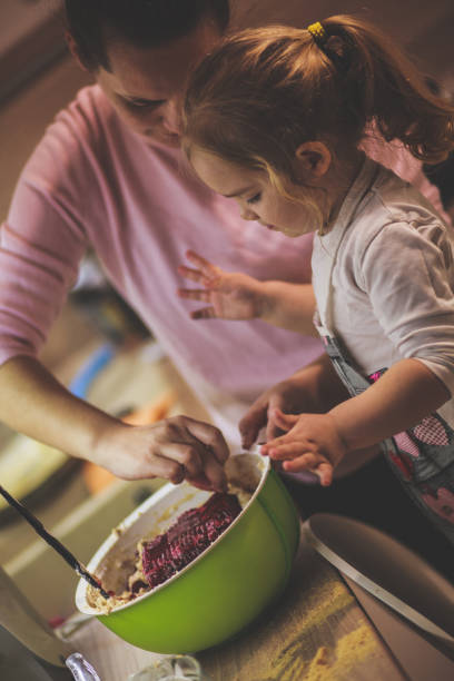 istock Mother letting her toddler assist her in the kitchen while they are making a cheesecake 1236469549