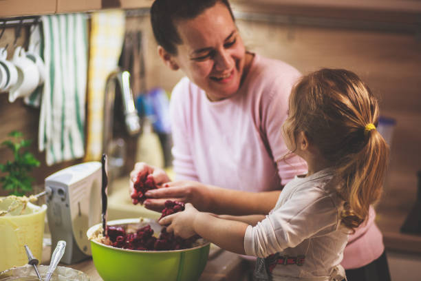 istock Happy mother and daughter bonding while making a tasty cheesecake 1236469579