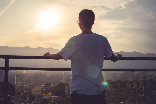 istock Young men looking sunrise on city rooftop 1236573330
