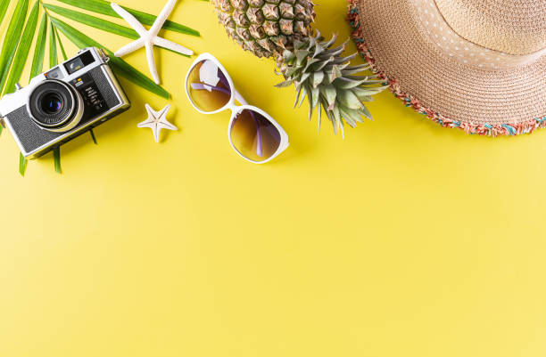 istock Colorful summer and holiday concept, Straw hat, sunglasses, palm branches, pineapple, star fish  and retro camera on yellow background. 1236674881