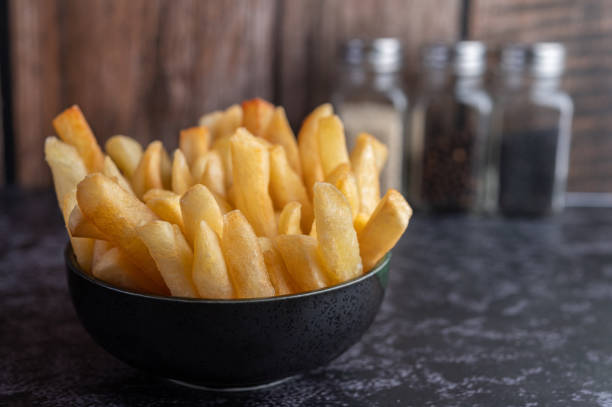 istock French fries in a black cup on the cement ground. Selective focus. 1236743489